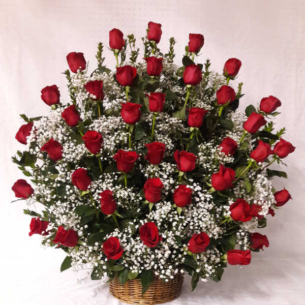 Large dome-shaped basket arrangement of red roses and white filler flowers