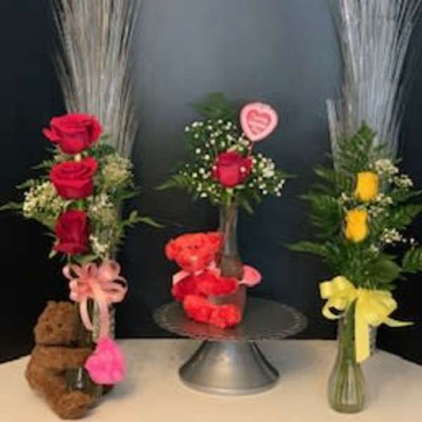 Three rose arrangements with teddy bears and ribbons
