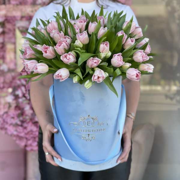 Pink tulips arranged in a light blue hatbox