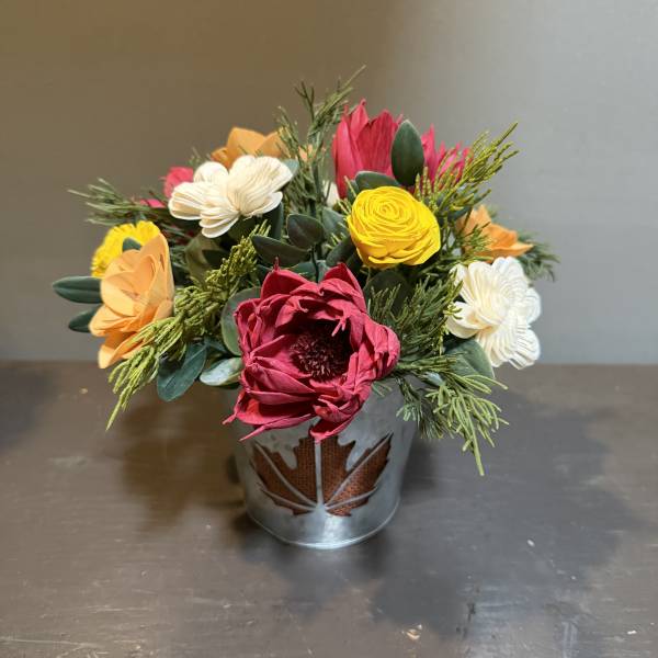 Colorful bouquet in a metal container with red, yellow, white, and orange blooms