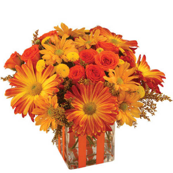 Orange and yellow mixed flower bouquet in a clear square vase