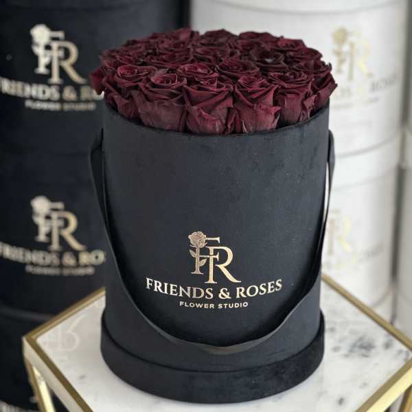 Box of deep burgundy roses in a black round hatbox