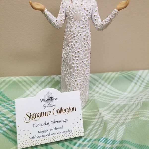 Decorative angel figurine in a white dress with raised arms