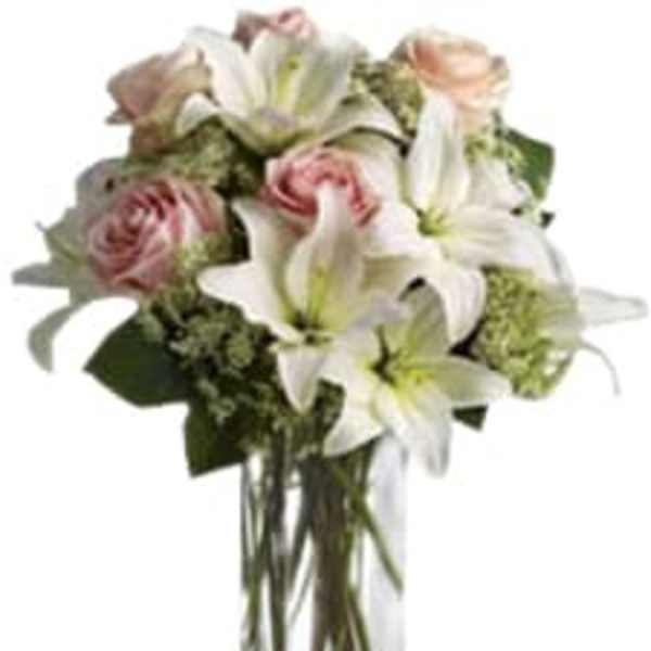 Bouquet of white lilies and pink roses in a clear glass vase