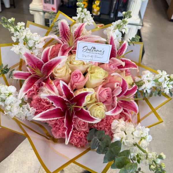 Pink and cream bouquet with lilies and roses wrapped in white paper