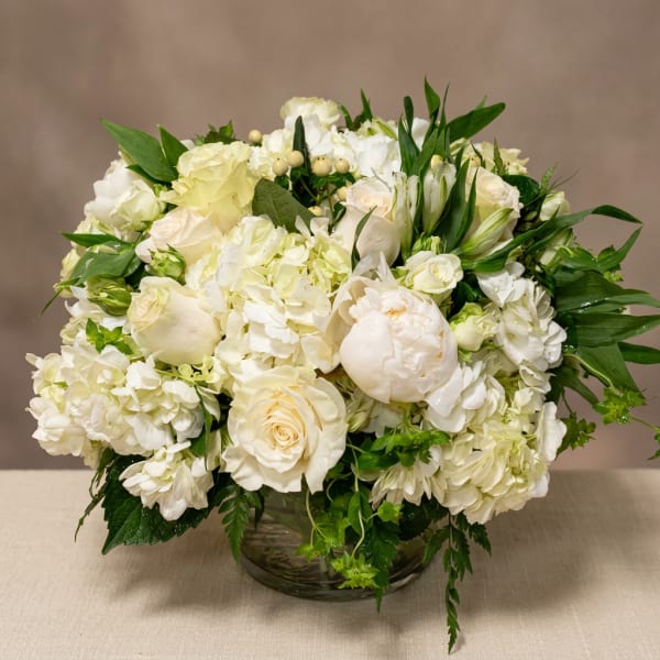 Cream and white flower arrangement in a glass bowl vase
