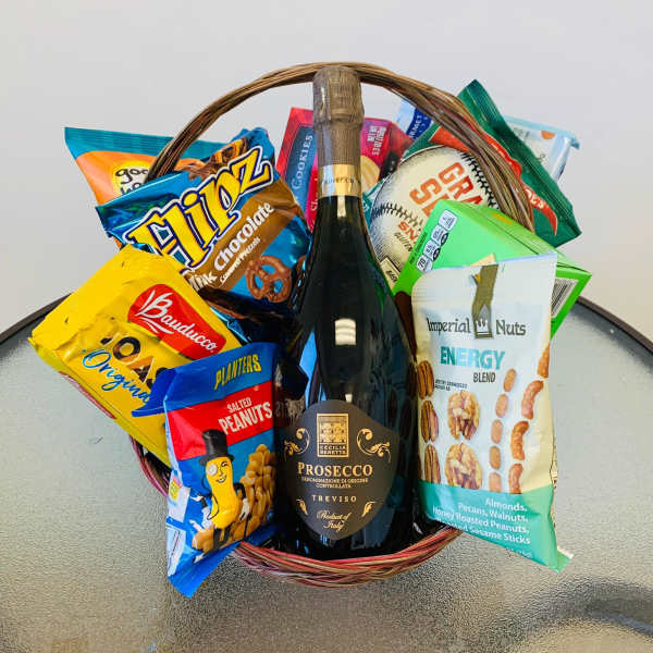 Basket of snacks with a bottle of prosecco