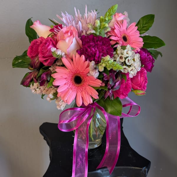 Pink and magenta mixed bouquet in a glass vase with a ribbon