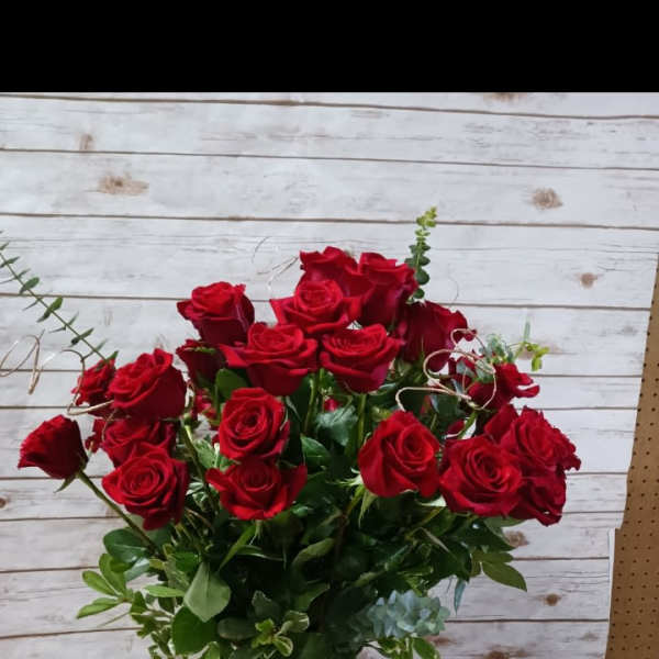 Red roses arranged in a clear glass vase