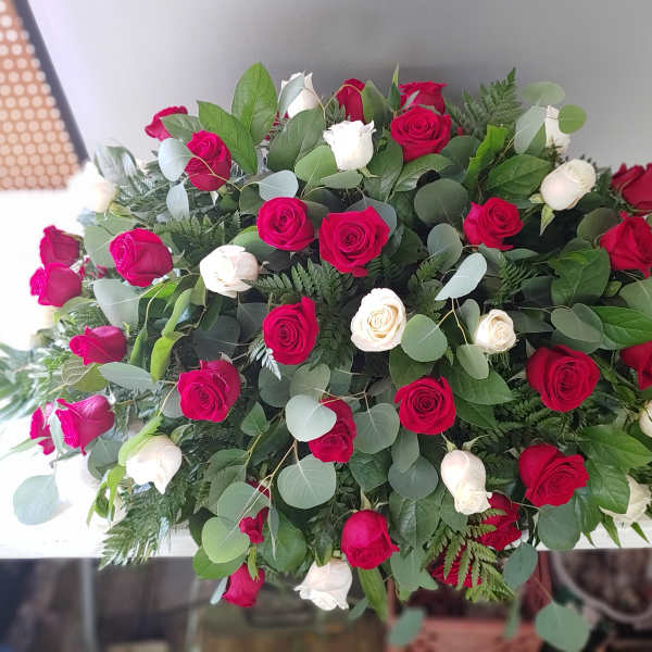 Large bouquet of red and white roses with mixed greenery