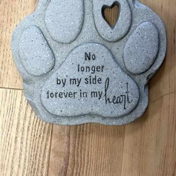 Gray paw-shaped memorial plaque with the words "No longer by my side forever in my heart"