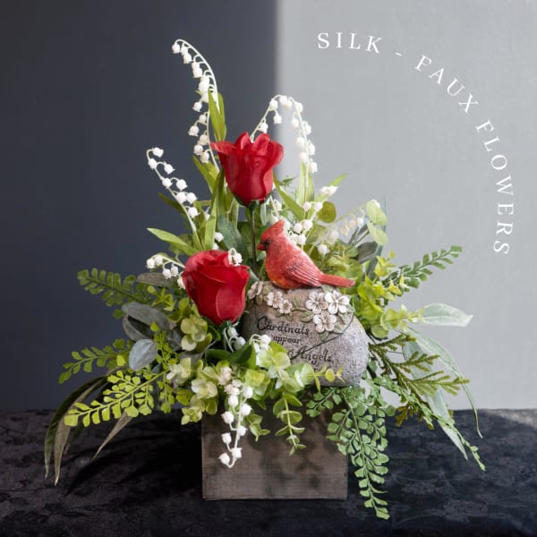 Silk red roses and white lily-of-the-valley in a rustic box with a cardinal figurine