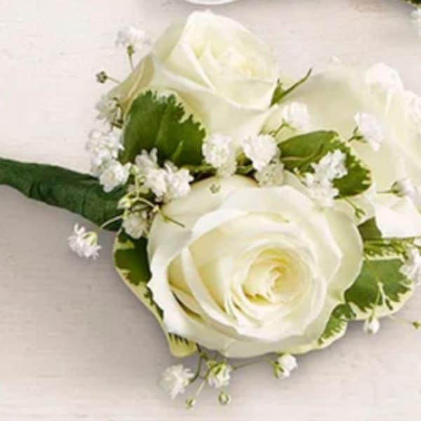 White rose boutonniere with small white filler flowers
