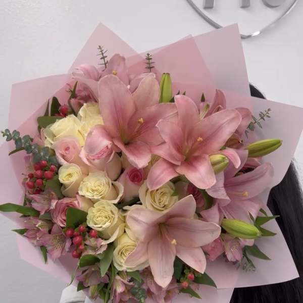 Pink lilies and cream roses in a wrapped bouquet