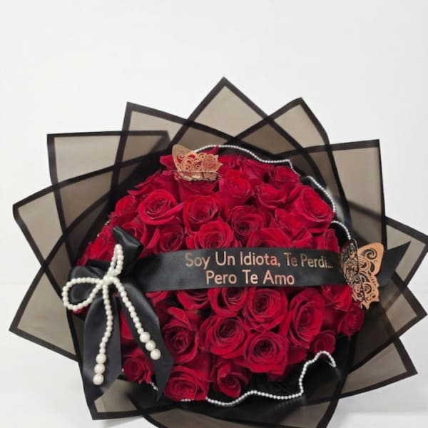 Bouquet of red roses wrapped in black paper with a ribbon and pearl accents