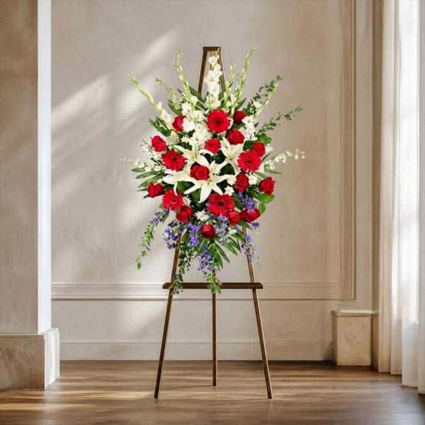 Standing floral spray with red and white flowers on an easel