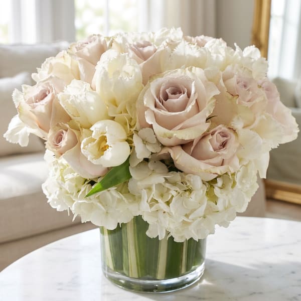 Blush roses and white hydrangeas in a clear glass vase