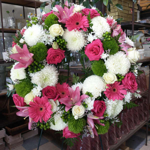 Large pink and white floral wreath on an easel