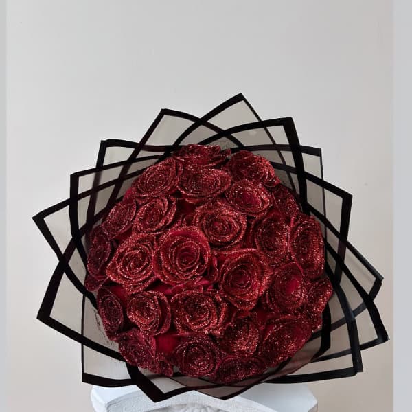 Bouquet of glittery red roses wrapped in black-edged paper