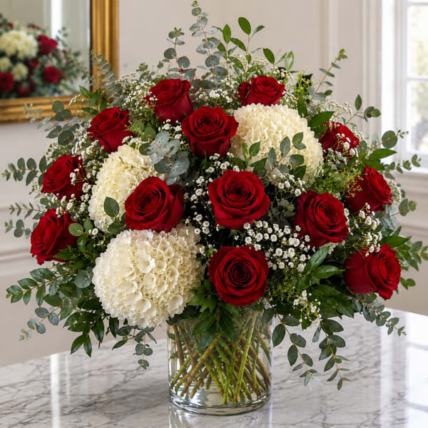 Red roses and white hydrangeas in a clear glass vase