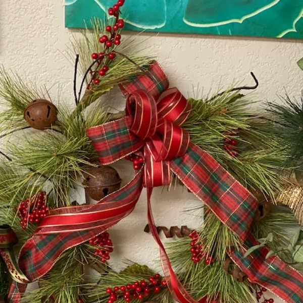 Holiday wreath with pine, red ribbon, berries, and bells