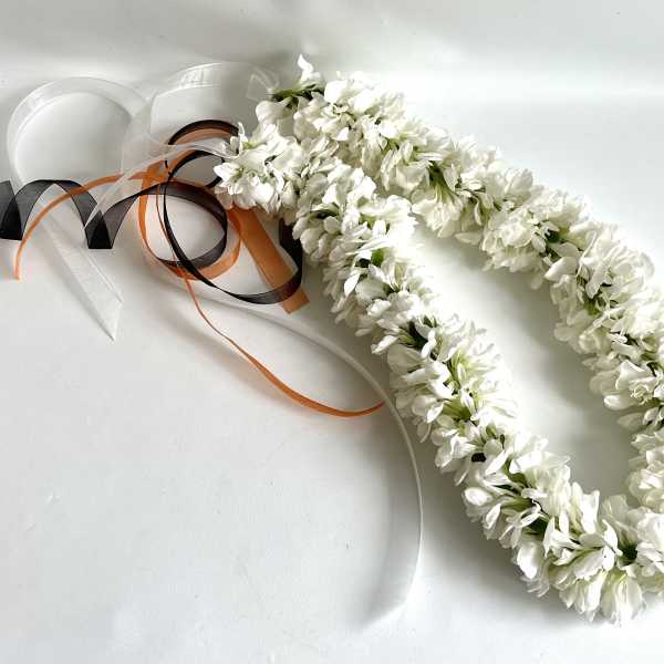 White floral lei with black, orange, and white ribbons