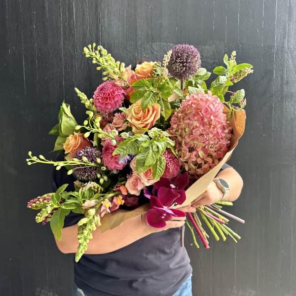 Handheld bouquet with pink hydrangea, peach roses, and purple allium