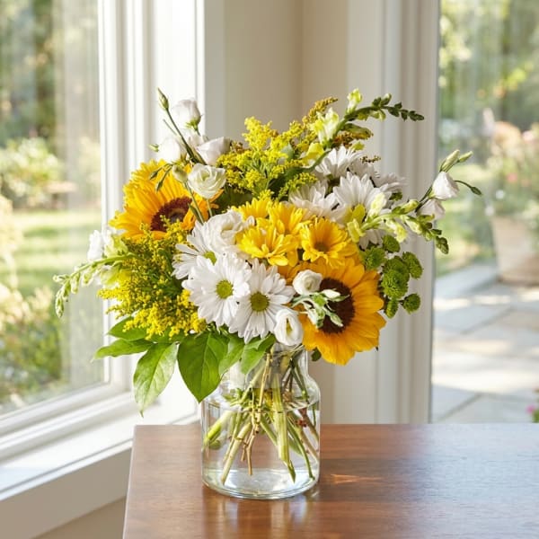 Sunflowers and white daisies in a clear glass vase