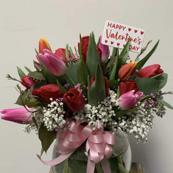 Bouquet of pink and red tulips with baby's breath and a Valentine's Day sign