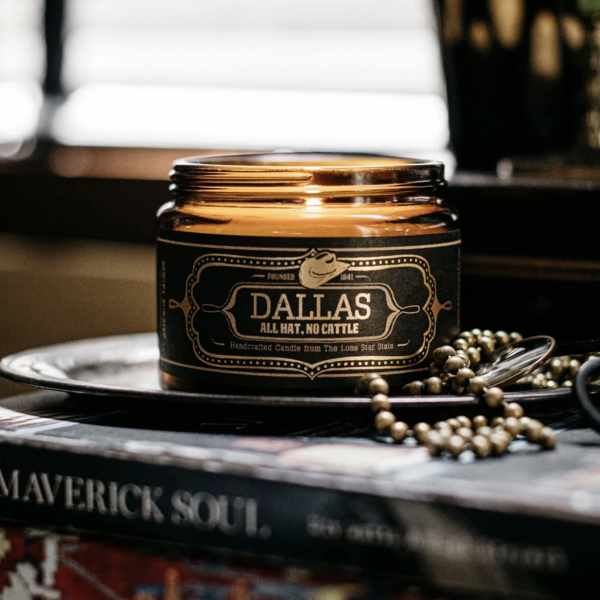 Amber glass candle jar with a black label on a tray
