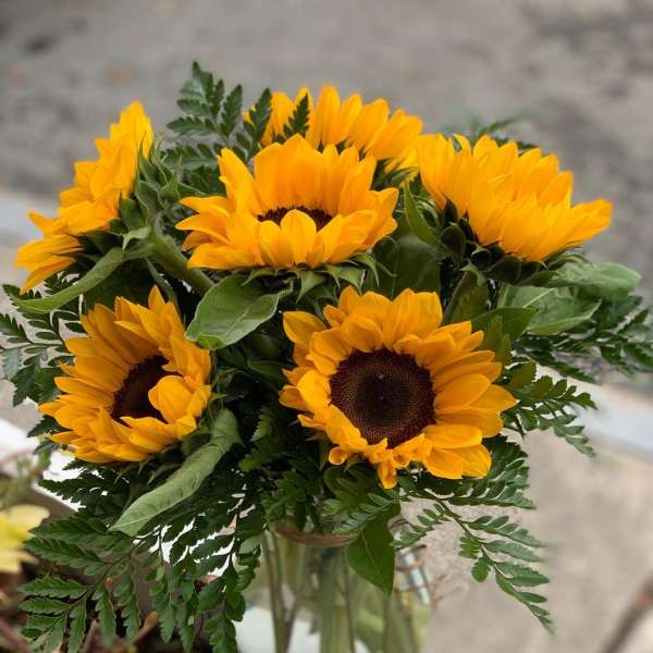 Bouquet of yellow sunflowers in a clear glass vase