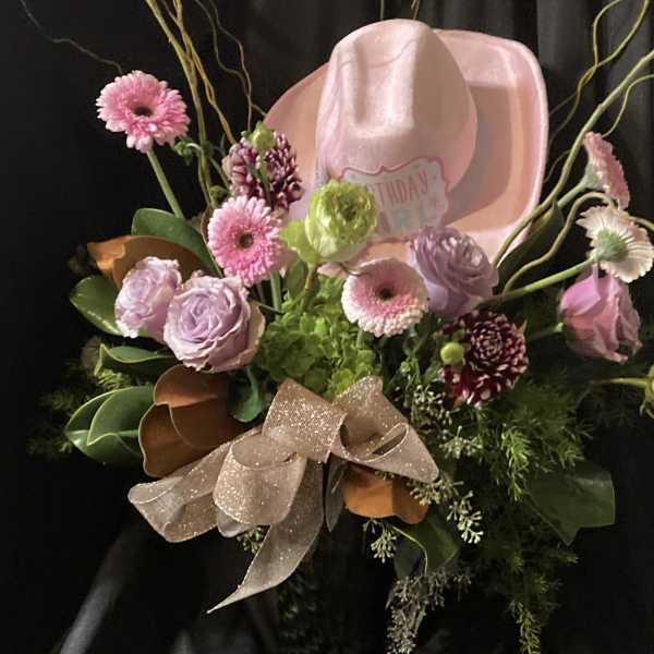 Pink and lavender bouquet with a pink cowboy hat and glittery ribbon