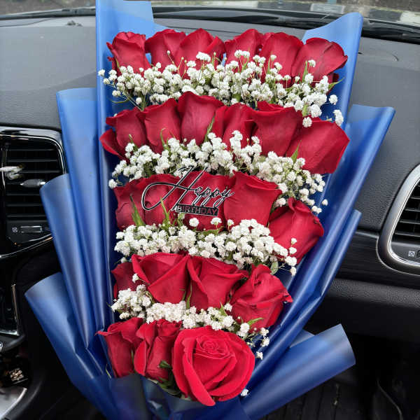 Bouquet of red roses with white baby's breath and a birthday pick
