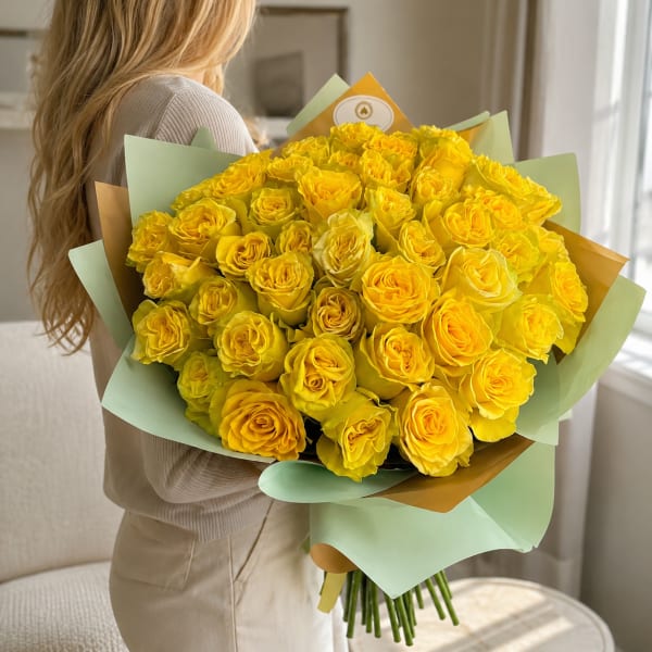 Large bouquet of yellow roses wrapped in pastel paper