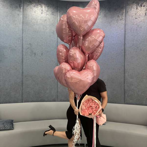 Pink heart balloons with a bouquet of pink roses