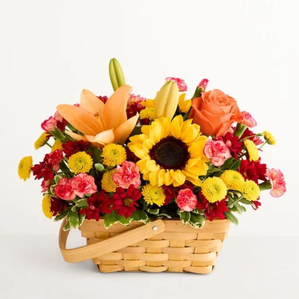 Mixed flower basket with a sunflower, orange lily, and roses