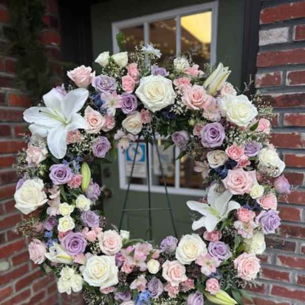 Pastel floral wreath with roses and lilies on a stand