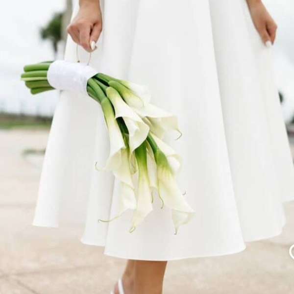 Bride holding a bouquet of white calla lilies