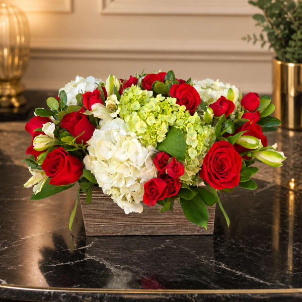 Red roses and white hydrangeas in a rectangular wooden container