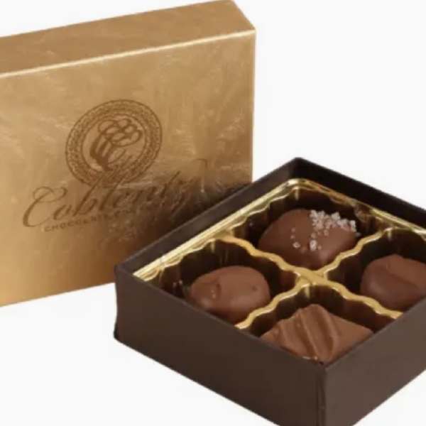 Box of assorted chocolates with a gold lid and brown tray