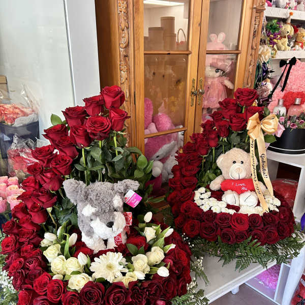 Heart-shaped rose arrangements with teddy bears and ribbon bows