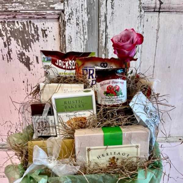 Gift basket with assorted packaged foods and a pink rose