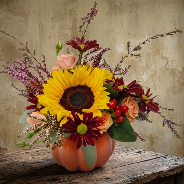 Sunflower and mixed flower arrangement in a pumpkin-shaped vase