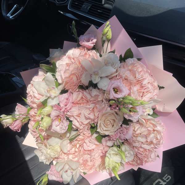 Pink and white bouquet with roses and lisianthus wrapped in pastel paper