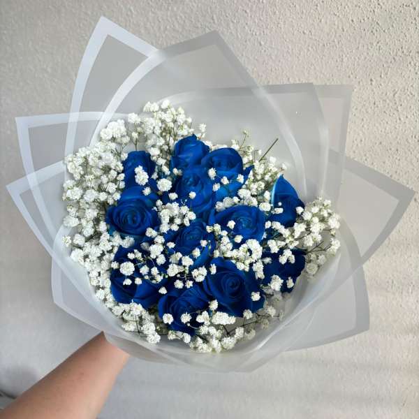 Bouquet of blue roses with white baby's breath in translucent wrap