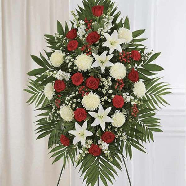 Standing floral spray with red roses, white lilies, and white pompons