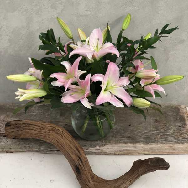 Pink lilies arranged in a clear glass vase
