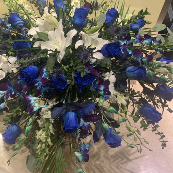 Large bouquet of blue roses and white lilies with mixed greenery
