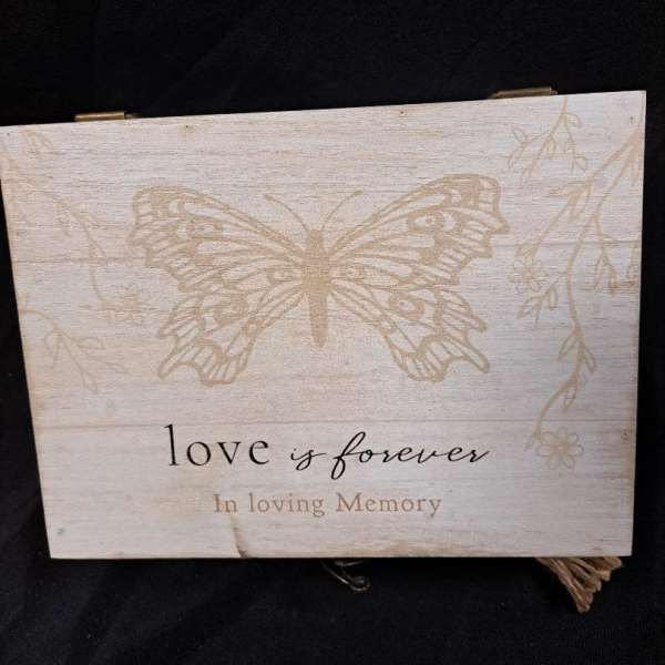Wooden memorial sign with a butterfly and the words "love is forever"