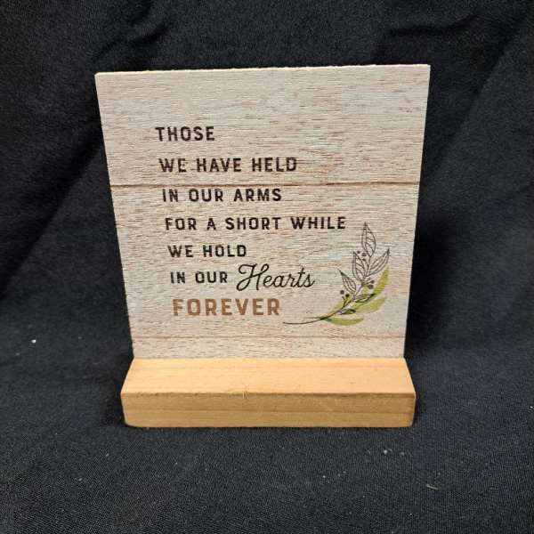 Wooden memorial plaque on a stand with a sympathy quote